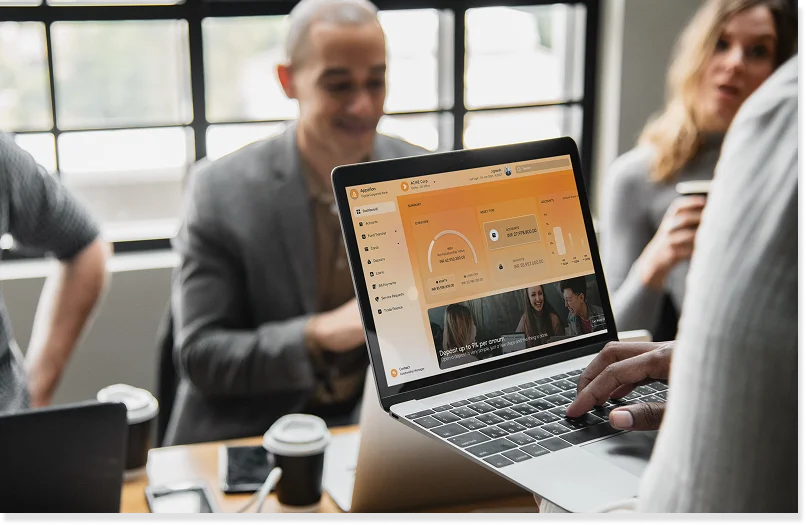 A banking professional using the Appzillon visual application design interface on a laptop to demonstrate how business owners can actively participate in low-code app development.